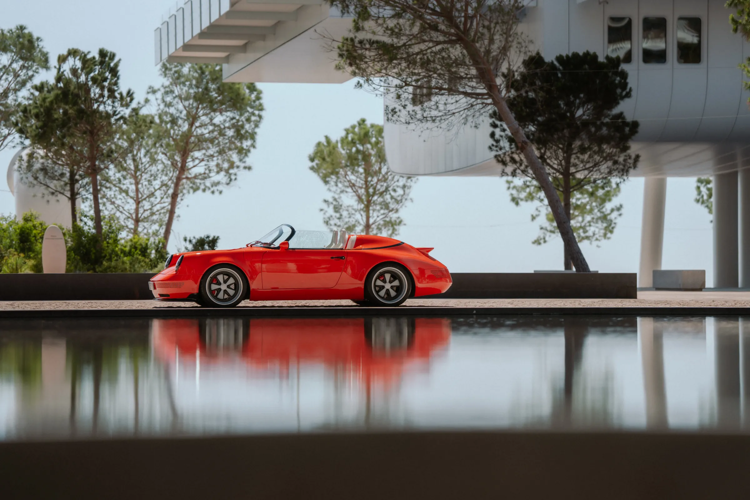 The Funkster reflected in a still pool beneath modern architecture